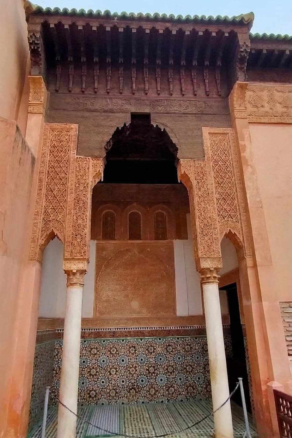 Close-up of a saturated zellige mosaic column at the Saadian Tombs, in cobalt blue, ochre, forest green and brick red